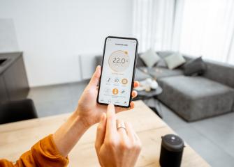 Temperaturen i vardagsrummet justeras med hjälp av en mobiltelefon.