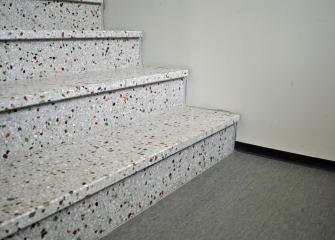 Kierrätyslasia mosaiikkibetoniportaissa Vantaan asuntomessujen Opaali-kerrostalossa.