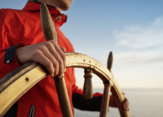 Ihminen laivan ruorissa.