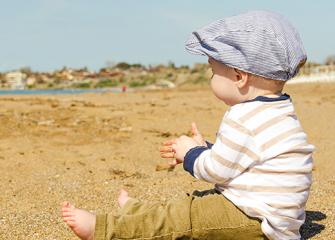 Lapsi istuu hiekalla.