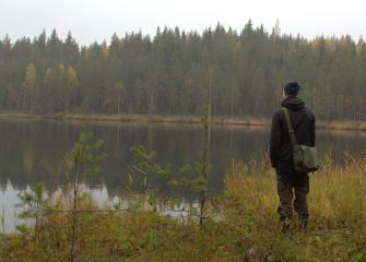 A person standing by a mossy pond, photo Roine Piirainen Kuvia-Suomesta.