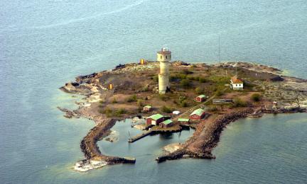 Ilmasta kuvattu majakka pienellä saarella. 