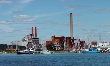 Veneitä satamassa ja taustalla teollisuuslaitos.