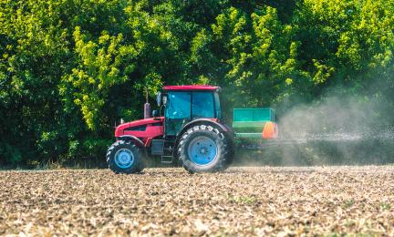 Traktori ruiskuttamassa torjunta-aineita pellolle.